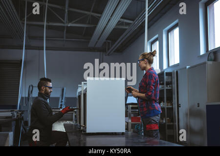 Two workers checking machine parts Stock Photo