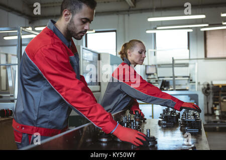 Two workers checking machine parts Stock Photo