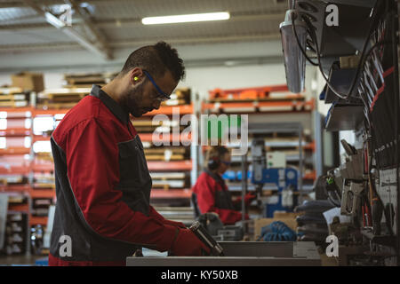 Male worker repairing a machine with tool Stock Photo