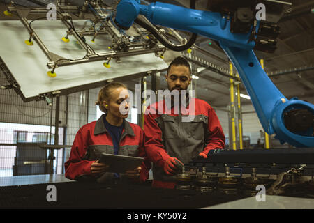 Two workers discussing over digital tablet Stock Photo