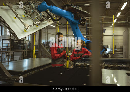Two workers discussing with each other in factory Stock Photo