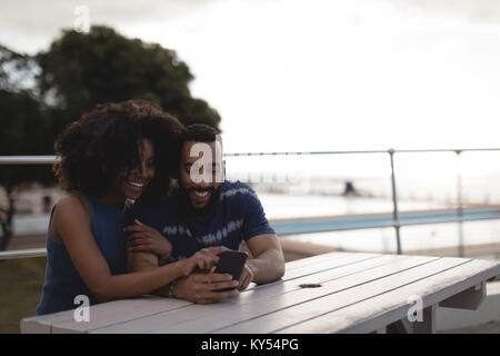 Couple using mobile phone on promenade Stock Photo