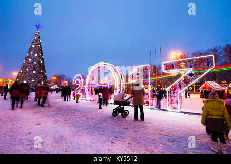 Gomel, Belarus - 25 December 2016: Plaza with walking people near the Christmas tree in the square. Glowing numbers 2017 Stock Photo