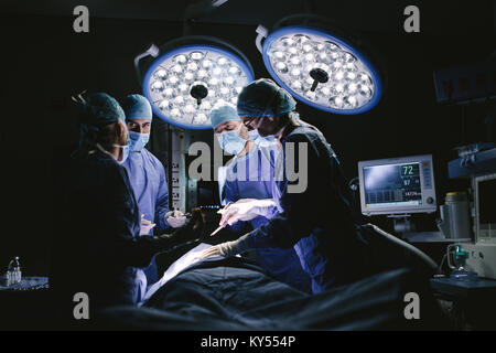 Medical team performing surgery in hospital. Group of surgeons at work in operation theater. Stock Photo