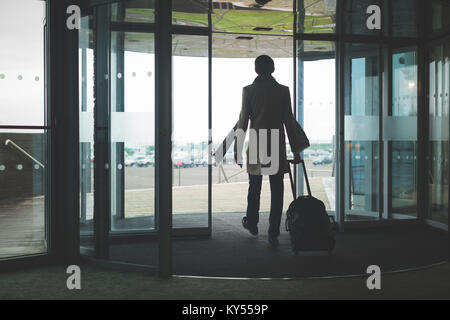 Businessman walking out of the hotel with baggage Stock Photo
