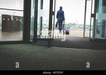 Businessman walking out of the hotel with baggage Stock Photo