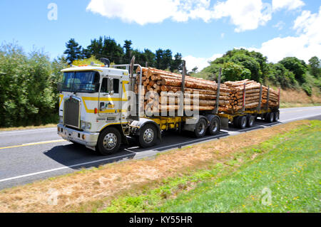 Logging truck traveling at speed on a New Zealand country road Stock Photo