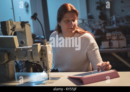 Tailor using digital tablet Stock Photo