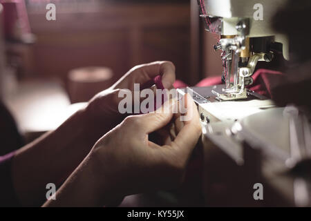 Tailor sewing cloth with sewing machine Stock Photo