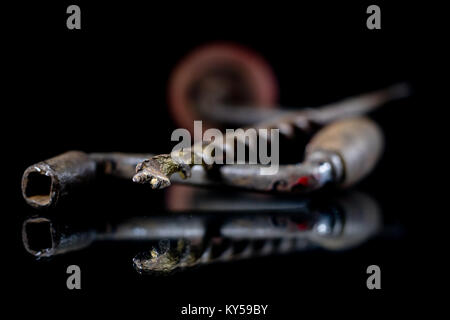 Old drill and drill with reflection in the mirror. Old drill and drill on a glass mirror table. Black background. Stock Photo