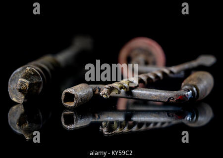 Old drill and drill with reflection in the mirror. Old drill and drill on a glass mirror table. Black background. Stock Photo