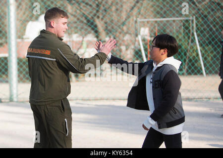 U.S. Marine Corps Cpl. Austin Stone, a radio technician with 1st Marine Aircraft Wing (MAW), III Marine Expeditionary Force, high fives a child after a game of soccer at Sun Rin Orphanage, Pohang, Republic of Korea, Dec. 16th, 2017. U.S. Marines with 1st MAW, along with Girl Scout leaders gave pajamas and toys to the children of Sun Rin Orphanage for the holiday season. (U.S. Marine Corps