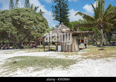 TADINE,MARE,NEW CALEDONIA-DECEMBER 3,2016: Tourists resting in the shade at Yejele Beach with rustic shelter and tropical trees in Mare, New Caledonia Stock Photo