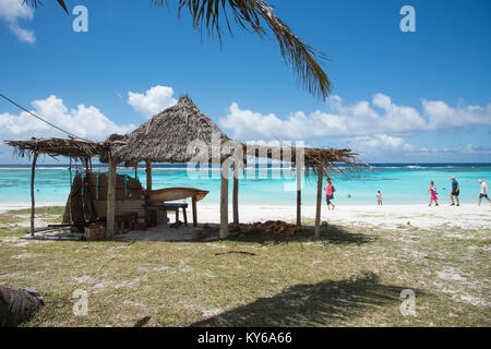 TADINE,MARE,NEW CALEDONIA-DECEMBER 3,2016: Rustic shelter and tourists on the stunning Pacific Ocean shoreline at Yejele Beach in Mare, New Caledonia Stock Photo