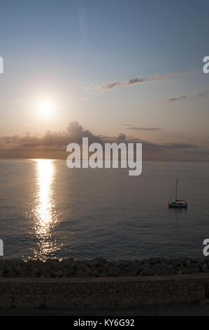 Corsica: a sailboat in the Mediterranean Sea seen at dawn from the dock of the port of Bastia, the city in the northeast at the base of the Cap Corse Stock Photo