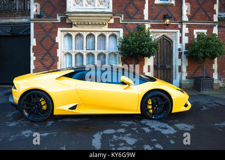 Yellow Lamborghini parked outside grand old house on Chequer Square next to the Norman tower & facing the Great churchyard, Bury St. Edmunds, Suffolk, Stock Photo