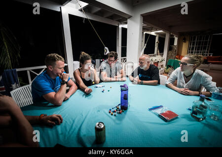 SAN ANDRES ISLAND, Colombia   Circa March 2017. Group of Adults playing Yum Dice Game at Night on the Balcony. Stock Photo