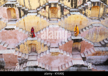 Two local women in traditional dress walking at the stepwell Panna Meena Ka Kund, Jaipur, Rajasthan, India. Stock Photo