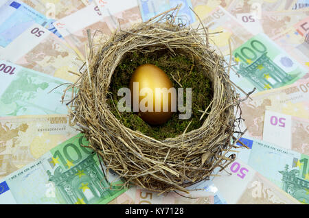 Golden eggs in a nest laying on a bed of money. Stock Photo