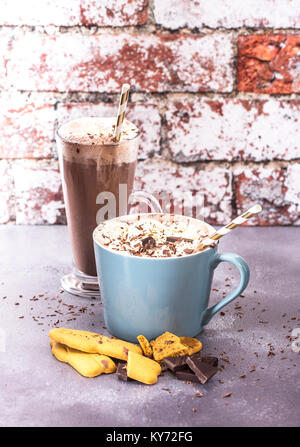 Two Hot Chocolate drinks with gingerbread and dark chocolate on a rustic background. Stock Photo