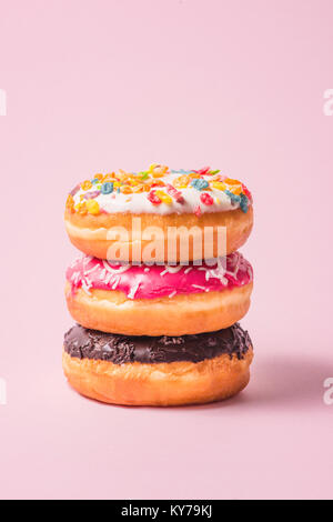 Delicious donuts for birthday on pastel pink background. Stock Photo