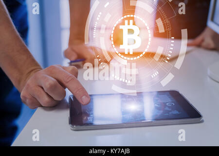 Team of financial people trading, investing or paying with bitcoin cryptocurrency technology, BTC currency symbol on virtual interface, digital tablet Stock Photo