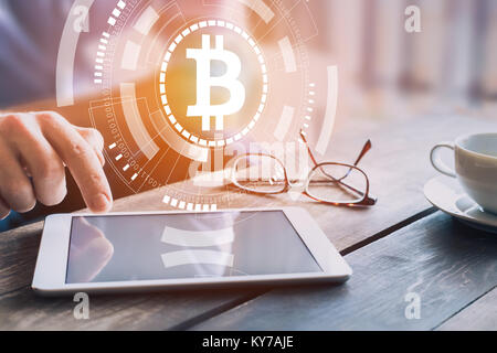 Bitcoin blockchain cryptocurrency technology concept with businessman investing, trading or paying on digital tablet computer with virtual interface w Stock Photo