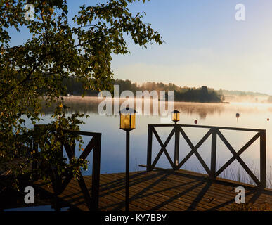 Wooden lakeside platform on misty summer morning, Ljustero,  Stockholm County, Sweden, Scandinavia. Stock Photo