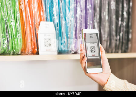 Hand scanning qr code with smartphone on showcase sale advertising shopping modern technology concept Stock Photo