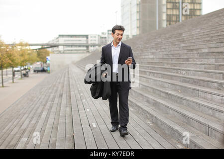 business man walking using smartphone to watch photos. Stock Photo