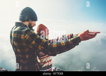 Couple Man and Woman holding hands raised together on mountain summit Love and Travel happy emotions feelings Lifestyle concept. Young family travelin Stock Photo