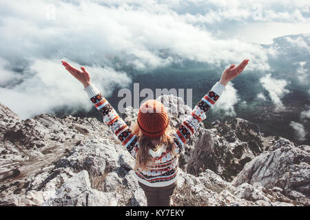 Happy woman traveler on mountain summit hands raised up Travel Lifestyle success concept adventure active vacations outdoor over clouds harmony with n Stock Photo