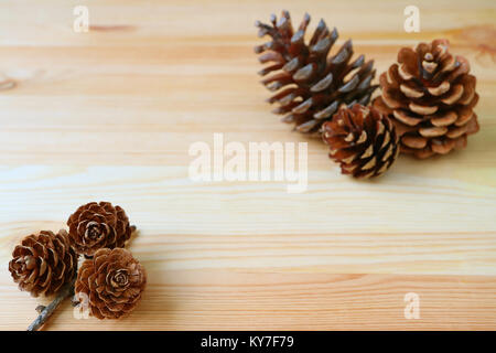 Natural Dry Rose-shape Mini Pine Cones and another Dry Pine Cones in Background, Isolated on Wooden Table with Copy Space Stock Photo