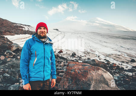Bearded Man traveler happy smiling with Elbrus mountain on background Travel Lifestyle concept adventure active vacations outdoor mountaineering climb Stock Photo