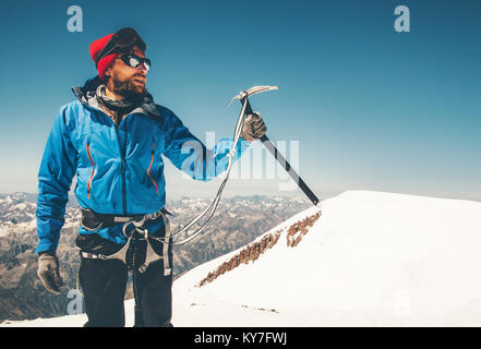Man climber holding ice axe on mountain glacier Travel Lifestyle concept adventure active vacations extreme outdoor mountaineering sport using alpinis Stock Photo