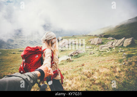 Couple travelers Man and Woman follow holding hands at foggy mountains landscape on background Love and Travel happy emotions Lifestyle concept. Young Stock Photo