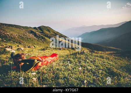 Man relaxing in sleeping bag enjoying sunset mountains landscape Travel Lifestyle camping concept adventure summer vacations outdoor hiking mountainee Stock Photo