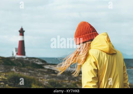 Traveler girl walking at Norway lighthouse sea landscape Travel Lifestyle concept adventure scandinavian vacations outdoor Stock Photo