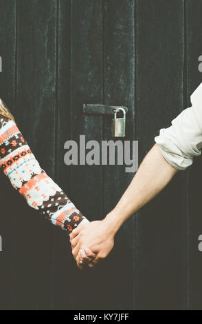 Love Couple hands holding forever together Lifestyle wooden background and lock over people taboo concept Stock Photo