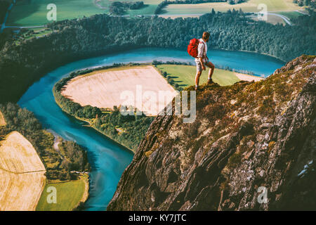 Hiking adventure in Norway mountains Man with backpack on cliff Travel lifestyle concept active weekend summer vacations river aerial view Stock Photo