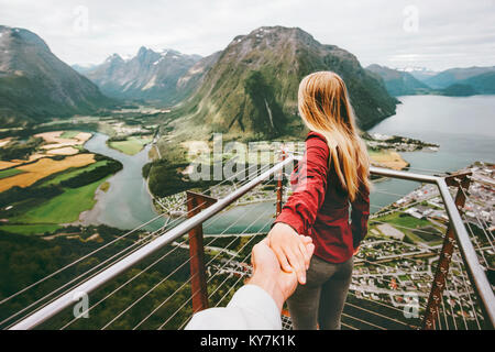 Couple Man and Woman follow holding hands in Norway mountains Love and Travel happy emotions Lifestyle concept. Young family traveling active adventur Stock Photo