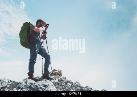 Man photographer with big backpack and camera taking photo of mountains Travel Lifestyle hobby concept adventure hiking vacations outdoor Stock Photo