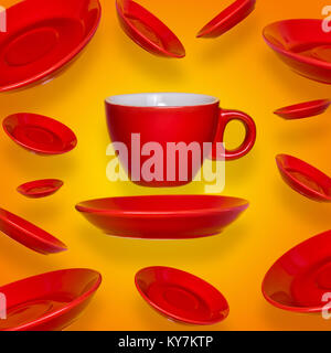 Creative surreal design with a red coffee cup and saucer on a yellow background. A cup and saucers flying in the air Stock Photo
