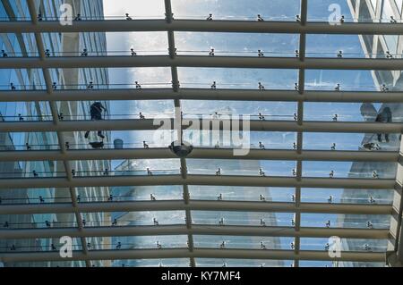 Two workers clean the glass roof of a shopping center in Mexico City. Stock Photo
