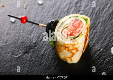 Pancake with salmon and salad leves roll Stock Photo