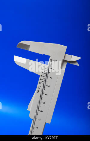 Closeup of gray plastic sliding callipers isolated on blue background Stock Photo
