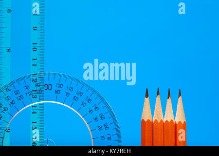 Transparent plastic protractor and ruler near pencils on blue background with copy space Stock Photo