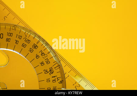 Transparent plastic protractor and ruler on yellow background with copy space Stock Photo