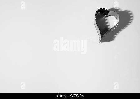 Heart shape made from a 35mm camera black and white film on white background. Stock Photo