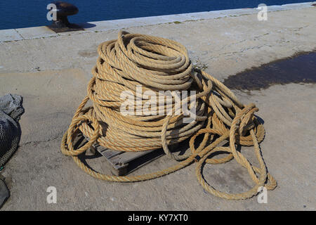 Fishermans coiled rope on quayside Stock Photo